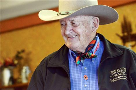 Top, Charley Lyons gives credit to the washtub for helping to pay for his St. Ignatius ranch. Above, Charley Lyons celebrates with friends in Arlee Saturday after returning from a banquet where he was inducted into the Montana Cowboy Hall of Fame.