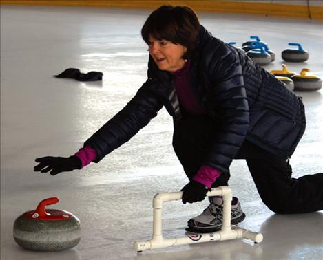  Connie Brownell releases her stone,  using a stabilizer  to hold the  classic curler’s  push-off. 