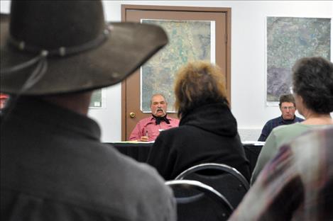 Flathead Joint Board of Control Chairman Jerry Laskody speaks with a lobbyist reporting via telephone from Helena as the crowd looks on.