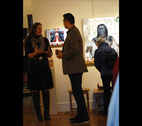 Artist Ben Pease, left, discusses his work with Heather Holmes in a front of a large Pease painting 