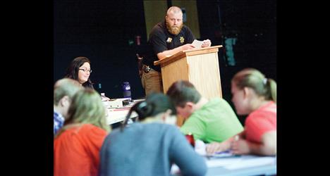 Ronan School Resource Officer Levi Read watches students scribble answers in Academic Bowl. 