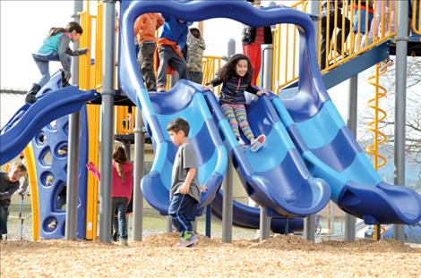 Karen Peterson photo Schoolchildren enjoy new playground equipment at St. Ignatius Elementary School.