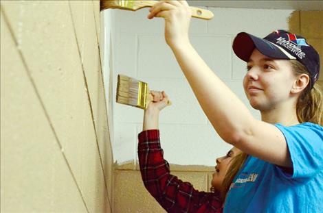 Students Elizabeth Morigeau and Haley McCormack help paint the YES program classroom.