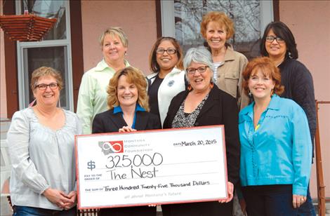 Grant money is presented to The Nest director Jenifer Blumberg by Mary Rutherford, chief executive officer and president, right, and Mary Craigle, board chair of the Montana Community Foundation, Also pictured are Lisa Skalsky, board president, left, front row; Back row, from left, are advisors Annie Engebretson, Joan Hart and Lucy McCrumb and board member Emily Colomeda.