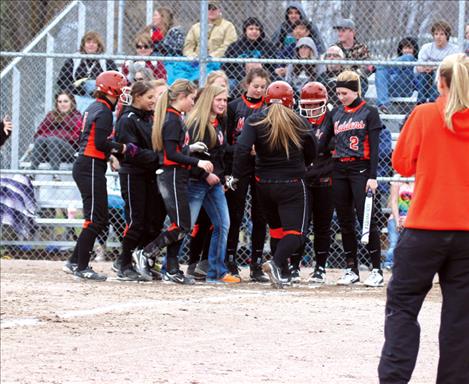 Maiden Amanda Morency is met at the plate by her teammates after launching a homerun over the fence in the Maidens opening game against MAC.