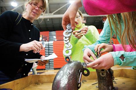 Students create sculptures using magnets and washers.