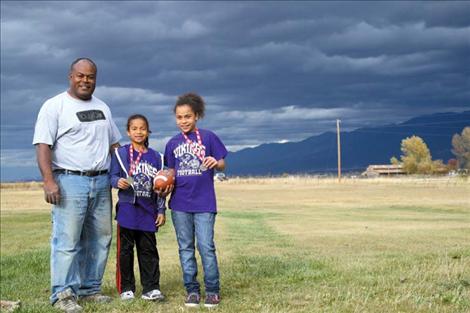 From left to right: Dad Emosi beams as daughters Adriana and Karalaini Tatukivei show off their Punt, Pass and Kick medals at their home near Ronan. 