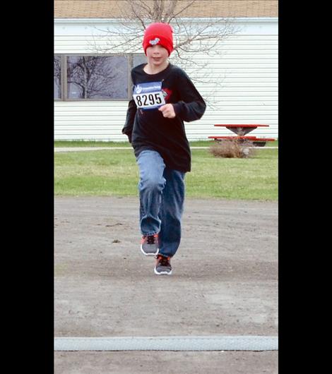 RJ Knoll, 11, was the first runner across the finish line with his 8:44 mile in the 1 Mile Fun Run.
