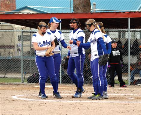 Fist bumps between innings shows Lady Bulldog support for one another. 