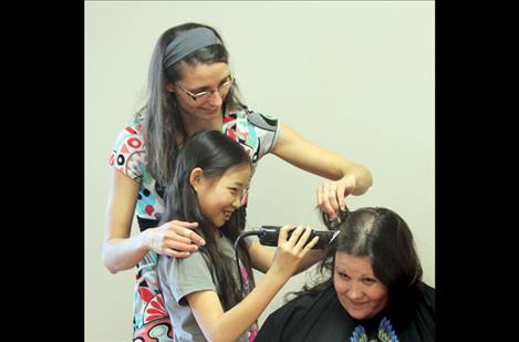 Lily shaves Laura’s head with some help from her mom. 