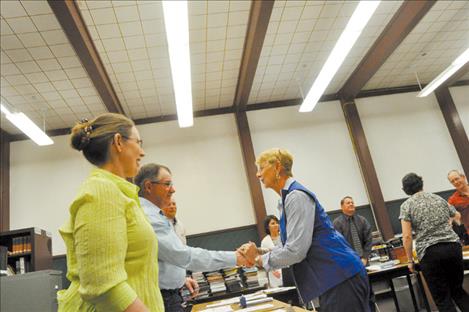 School board member Duane Wieble shakes the hand of Deborah Thrailkill, who presented a $100,000 donation to Charlo Schools. 