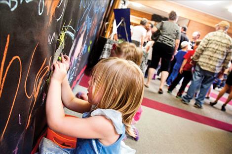 Children draw on paper walls, using their creativity as part of the school’s art festival.