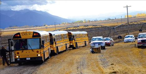 Polson school buses serve as a portable lunch room as fourth-graders move inside out of the wind during their noxious weed field study.