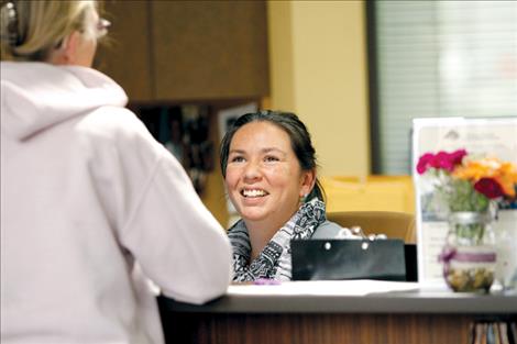Serena Clary visits with a patient from her spot behind the front desk at Polson Health, Kalispell Regional Healthcare’s new clinic on Polson Hill.