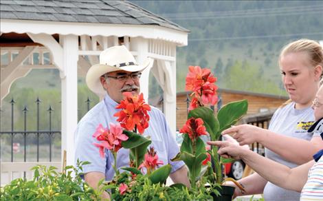 Visitors inspect flowers at the Arlee Farmers Market.