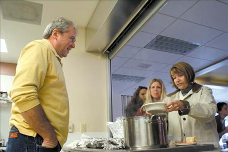 Virgil Dupuis mans the chow line as SKC’s Interim Academic Vice President Alice Oechsli helps herself to some stew. 