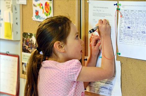 Cora Lapotka, 5, adds an item to next week’s agenda