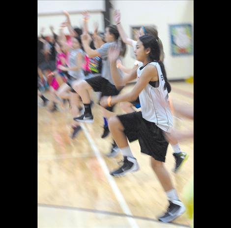 Girls work on their layup form at the youth clinic at Two Eagle River School gym.