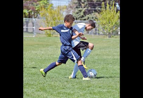 Trey Lichtenberg scrambles to maintain control of the ball during a U12 Polson FC boys’ soccer game May 9.