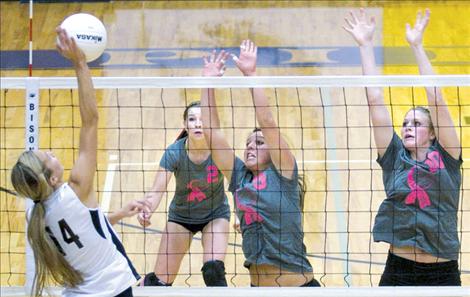 Sporting pink ribbons on their shirts in support of breast cancer  awareness, Lady Pirates Shalaina Duford and Heidi Rausch defend the net against Frenchtown, while teammate Katie Sprague provides backup. Polson won the match in a rousing victory on senior night last Thursday.