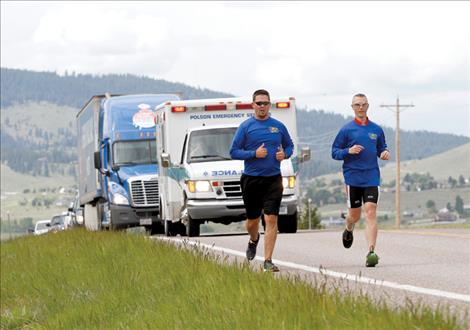 runners lead a procession into Polson Friday afternoon during the Special Olympics Torch Run.