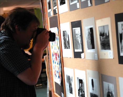 Two Eagle River School art teacher Sean Dalbey photographs student work at the annual Art Slam.