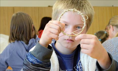 Chris Brown, 11, works on a dream catcher.