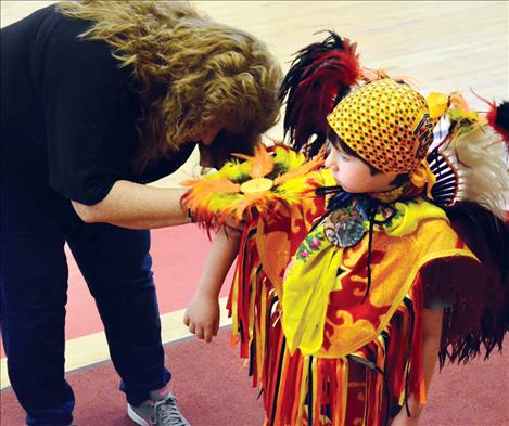 Trace Mesteth, 6, gets dressed for the powwow. 