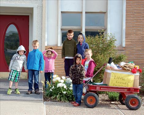 Little Friends preschoolers prepare to haul toys to Helping Hands for other children.
