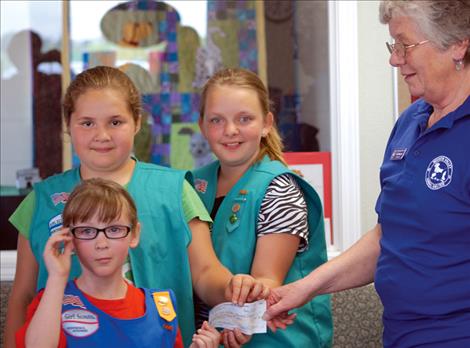 Girl Scout Troop 3422 members Maizy Blixt, left, Shawnte’ Erickson, and Harlee Stokes present a check to Jill Simpson, Mission Valley Animal Shelter director. Not pictured are scouts Lovelei Charlo, Aaliyah Stewart and Jadyn Lohs.