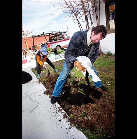 Kelly Ware and Jason Moore build flower beds around the co-op