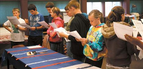 A line of grade-schoolers looks over their voting ballots while waiting for their chance to vote.