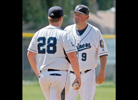 Coach Jami Hanson talks strategy with pitcher Micah McClure.