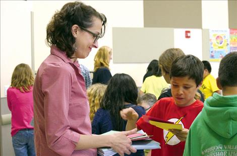 Poet Rachel Mindell receives a stack of thank you cards from students for teaching them about poetry.