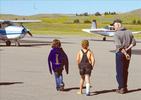 Two young ladies interested in flying walk to a plane (above) for a ride during the Young Eagles event Saturday held by Experimental Aircraft Association Chapter 1122.  