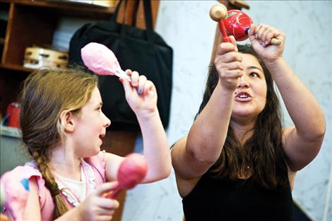 Charlo teacher Christina Madden helps Lilly Thinglestad try out some homemade maracas. 