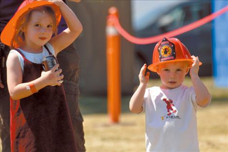 he Robine siblings don plastic hats for the St. Ignatius Fireman’s Picnic and Auction.