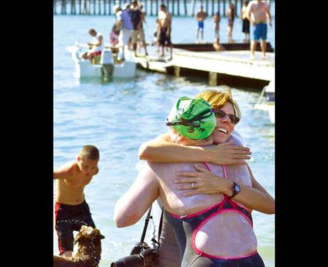Sarah Thomas gets a hug from swimming friend Dana Johnston at Riverside Park in Polson after completing her 28-mile swim.