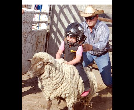 Brinley Jennison clings to the back of a sheep for a wild and wooly ride.