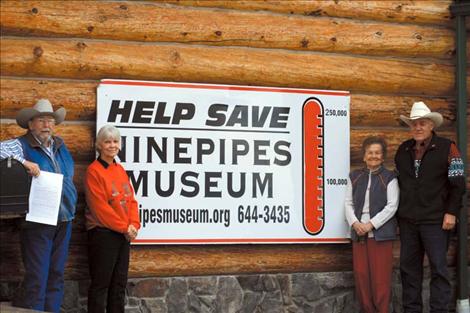 From left to right: Rod Wamsley, Laurel Cheff, Hope Stockstad and Bud Cheff pose outside the museum. Wamsley is holding the deed to the building.