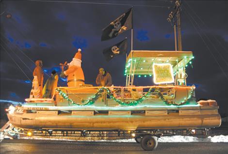 The Fisher family puts on the finishing touches of its "Pirates Christmas" float as dusk wanes prior to the Ronan Parade of Lights. 