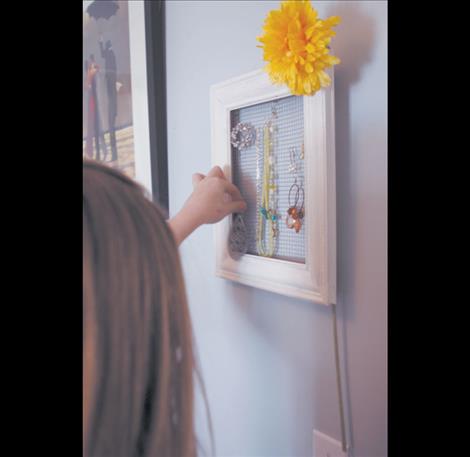 An old frame bought for a buck from a thrift store and painted white suits the hanging jewelry  beautifully. 