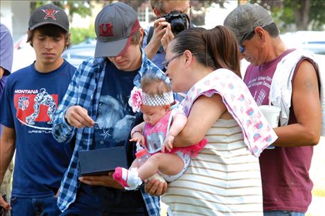 Shayne Pierre and his mother Francine, holding baby sister Elizabeth Mary, look at Shayne’s award.