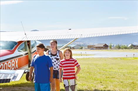  Trevor Acevedo, 11, Lisa Costilla, 14, and Nic Frost, 10, grin after taking a Young Eagles flight.