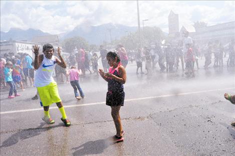 Kids play in water sprayed by the St. Ignatius Volunteer Fire Department.  