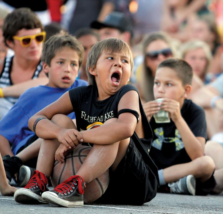 A young 3-on-3 contestant yawns after a long day of basketball while waiting for Saturday night’s slam dunk contest to begin.