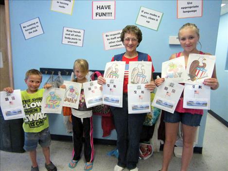 Pictured are:  Jonathan Erickson, 7, third place; Maia Christopher, 7, first place; Margaret Fay, Ladies Auxiliary President; Alex Loughin, 12, first place. Alex is holding a picture by Gaige Lindquist, 6, who won second place and Margaret Fay is holding pictures by DaShaundre Steele, 9, who won third place and Anna Danielson, 12, second place. 