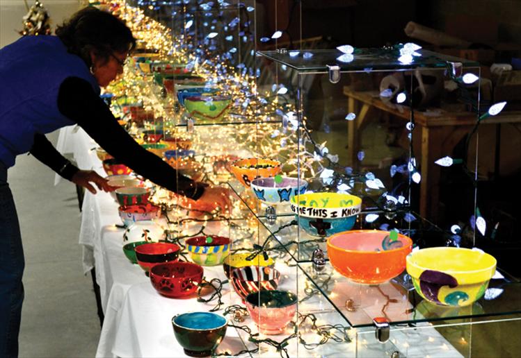 Trish Rodrique arranges colorful hand-painted bowls for sale from $5 to $20. The bowls were painted by local volunteers throughout the summer, then purchased at Saturday’s fundraiser and filled with a variety of soup and chilis.