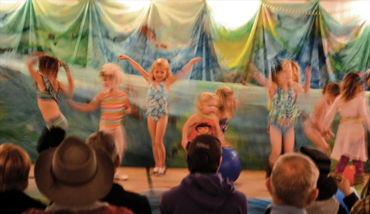 Tiny dancers become a colorful swarm of movement as they “swim” across the stage in the soup tent. The young performers take dance lessons from Julia Roberts at Mission Valley Dance.