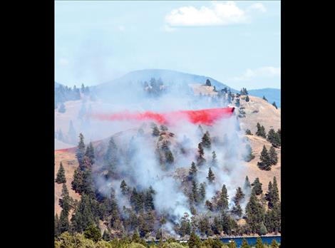 Berl Tiskus/Valley Journal A single-engine airtanker dumps fire retardant on the Wild Horse Island fire July 22.